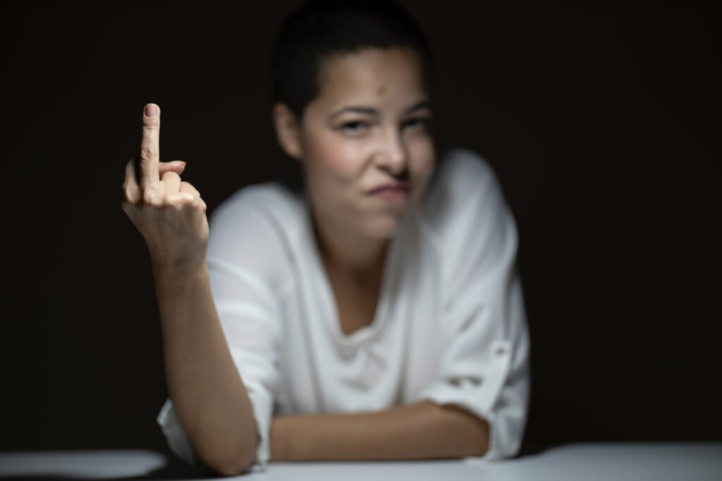 Woman looking angry and raising her middle finger